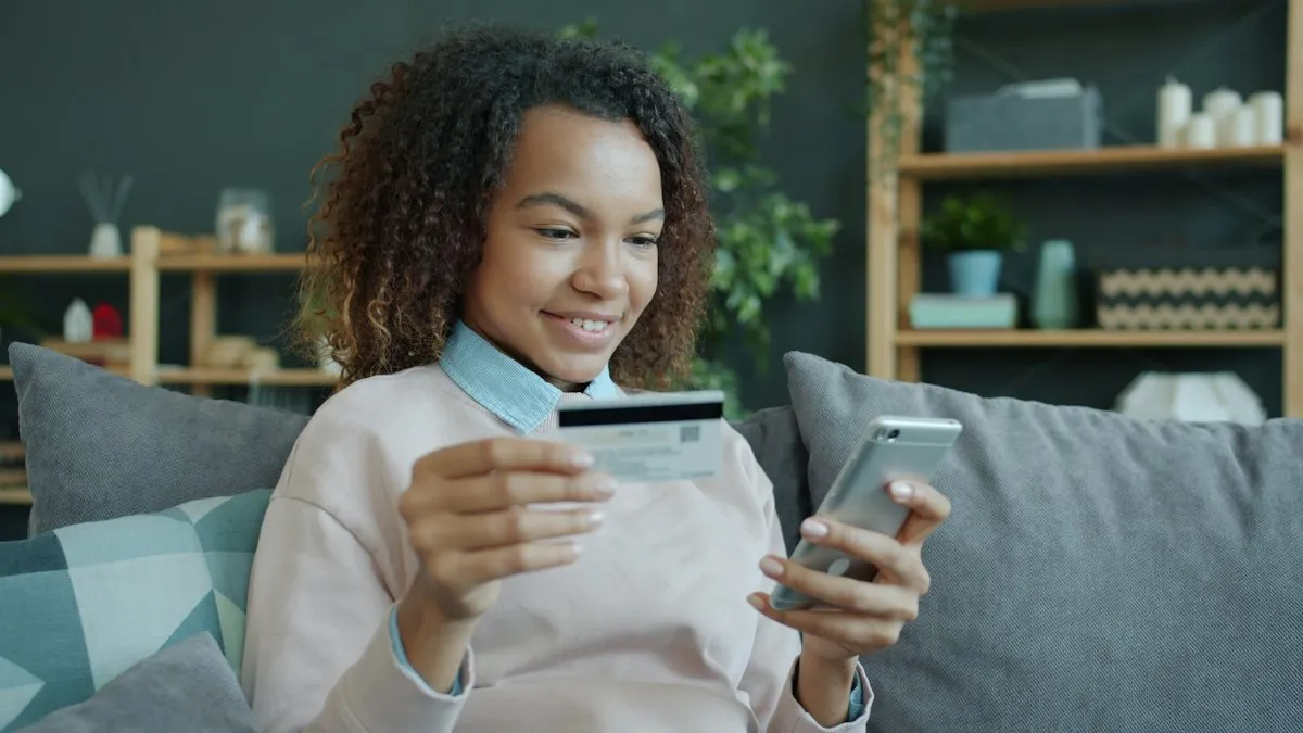 A woman paying online with her phone and card